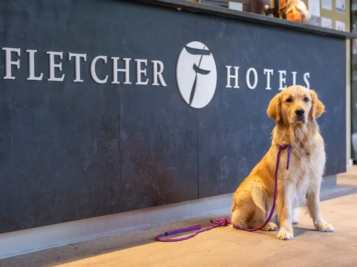 Bailey zit bij de balie van het Fletcher Hotel in Nunspeet tijdens haar eerste vakantie met Wouter.